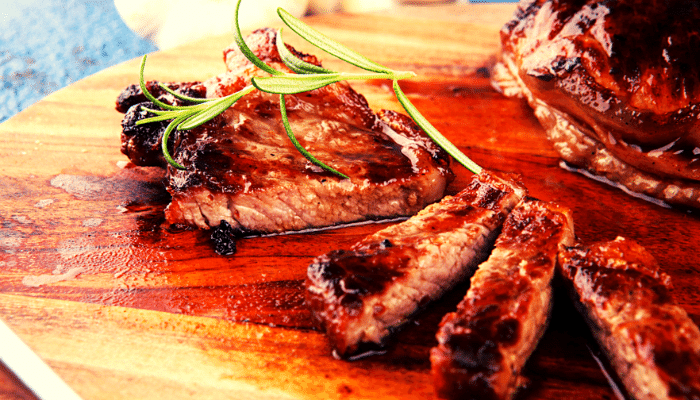 Carne da picanha feita na frigideira, colocada em tiras numa tábua de madeira própria para alimentos
