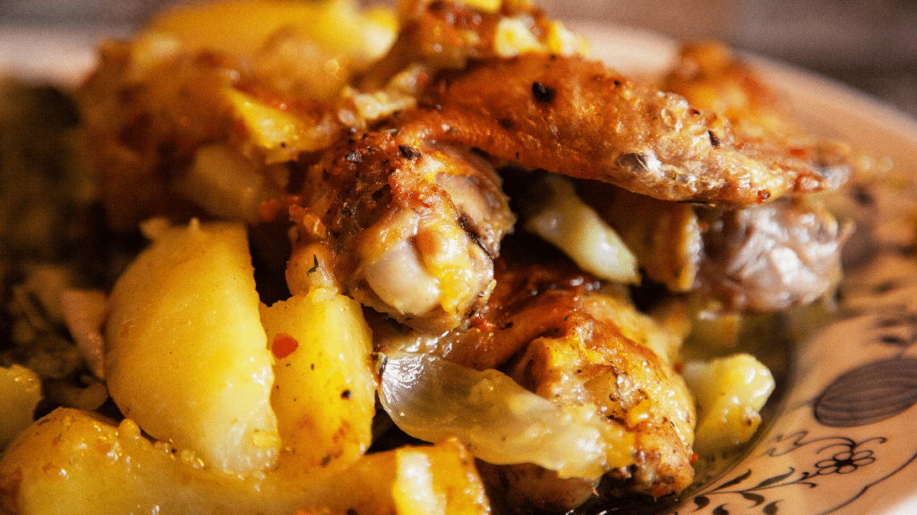 Receita de Frango no Forno com Batata pronto e apetitoso para comer, servido em um prato de cerâmica